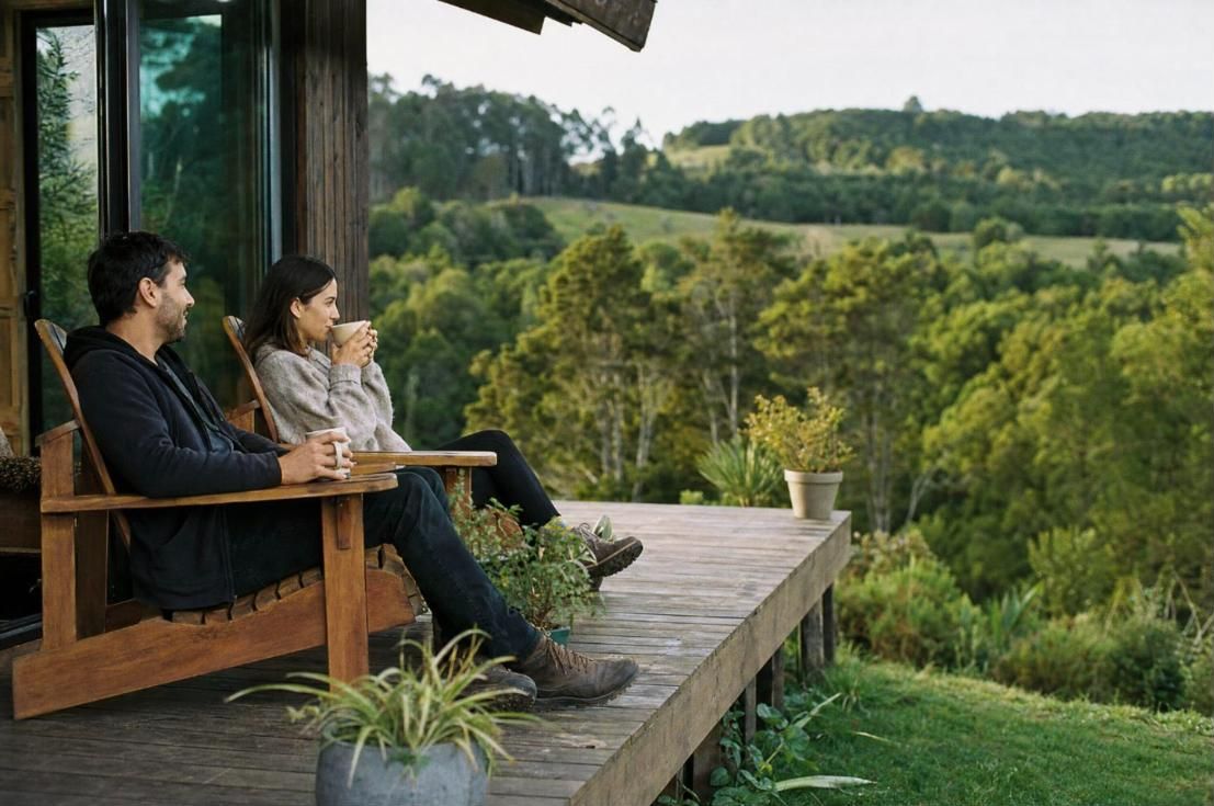 Pareja en una terraza de madera frente al bosque